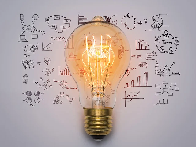 Lit vintage Edison bulb in front of sketches of a cloud, team, plan and charts, representing the elements of great web design