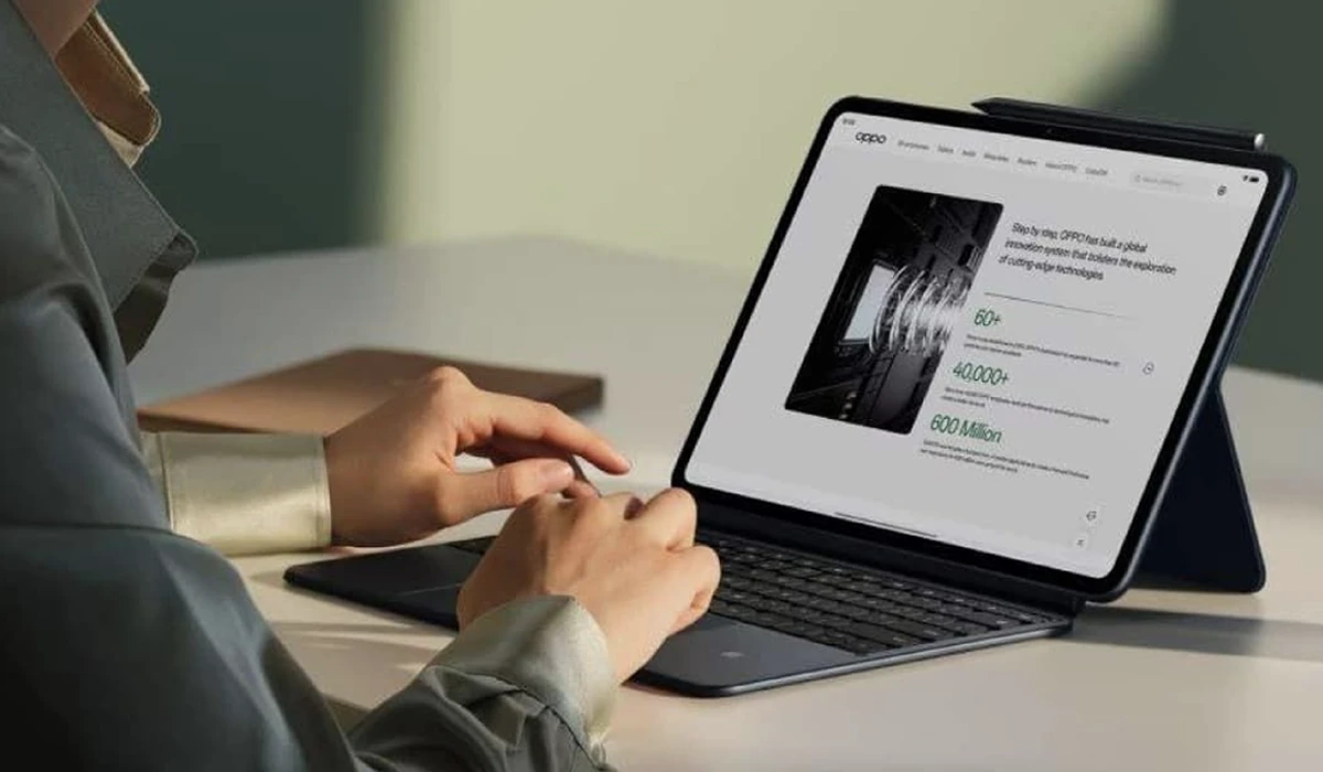 Hands typing on a tablet keyboard while reviewing a report