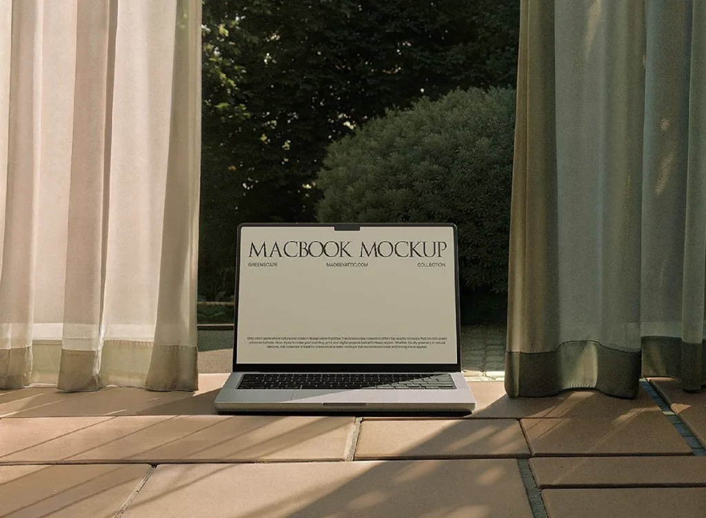 Laptop on a terrace between curtains, with a garden behind