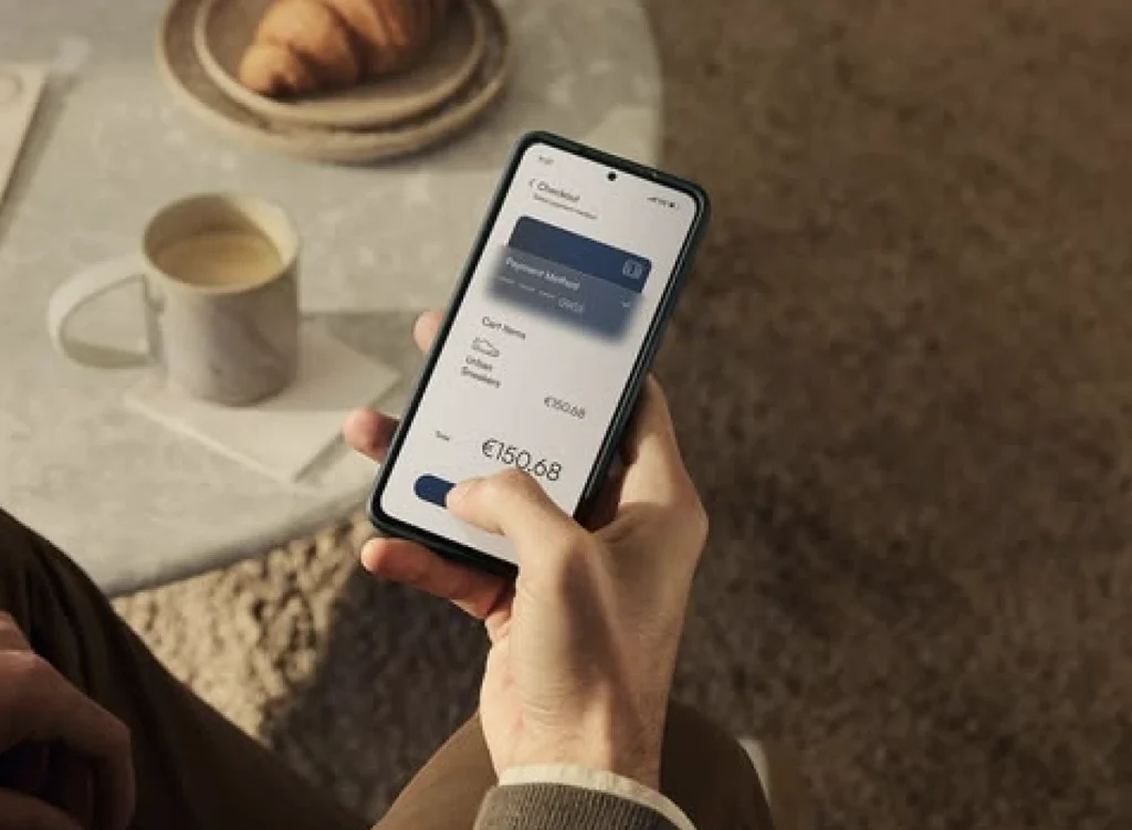 Hand holding a phone showing a mobile booking checkout